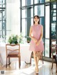 A woman standing in front of a dining room table.