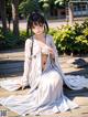 A woman in a white kimono sitting on a wooden deck.