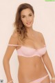 A woman in a pink bra and panties posing for a picture.